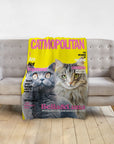 Personalized yellow Catmopolitan blanket featuring custom portraits of two cats, Bella & Luna, on a gray sofa.