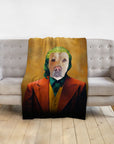 Personalized pet blanket with a dog portrait in a Joker-style costume, draped over a gray sofa.