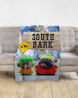 Personalized South Bark blanket featuring two dogs in cartoon style, draped over a gray sofa.