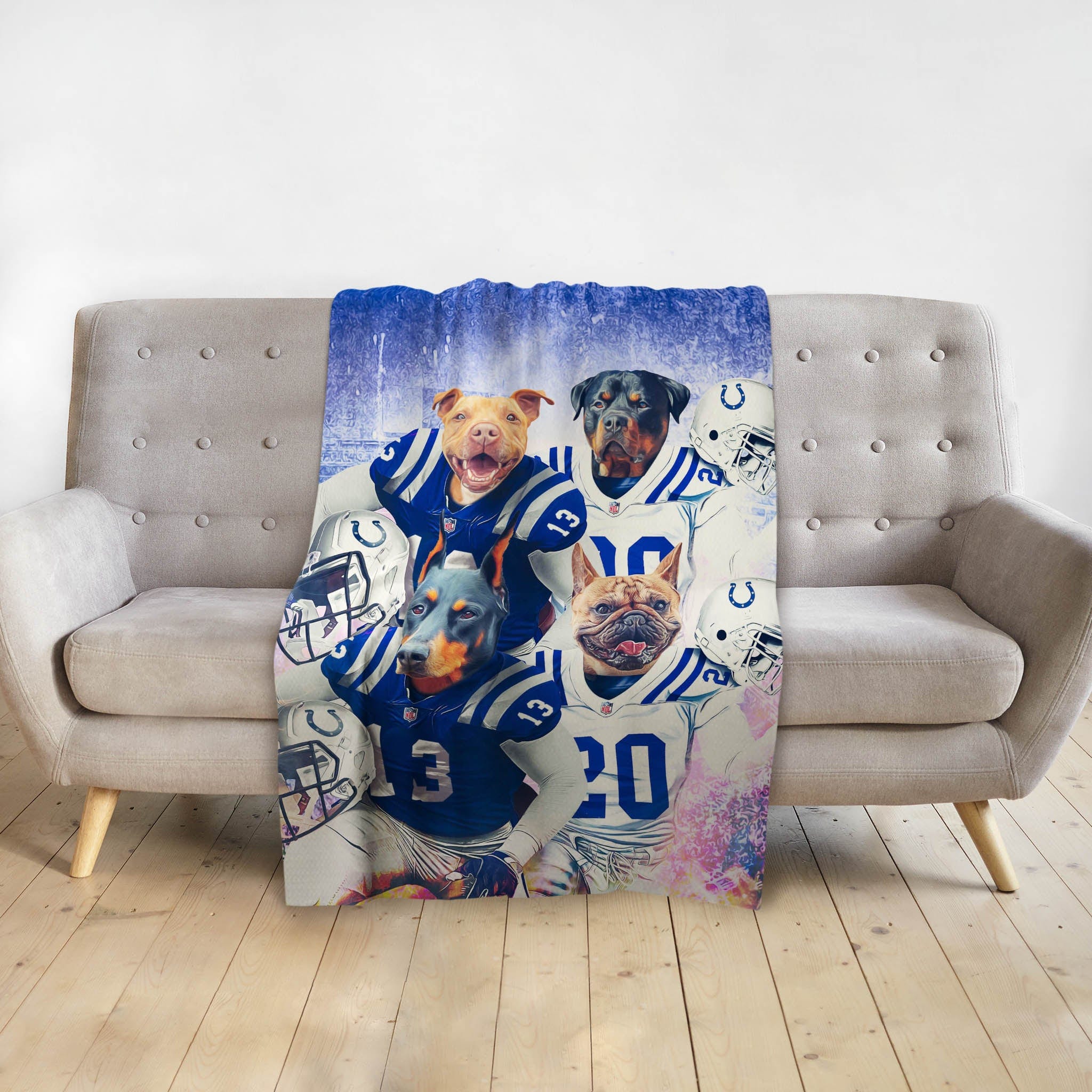 Personalized 4-pet blanket with dogs in blue and white football uniforms, draped over a gray sofa.