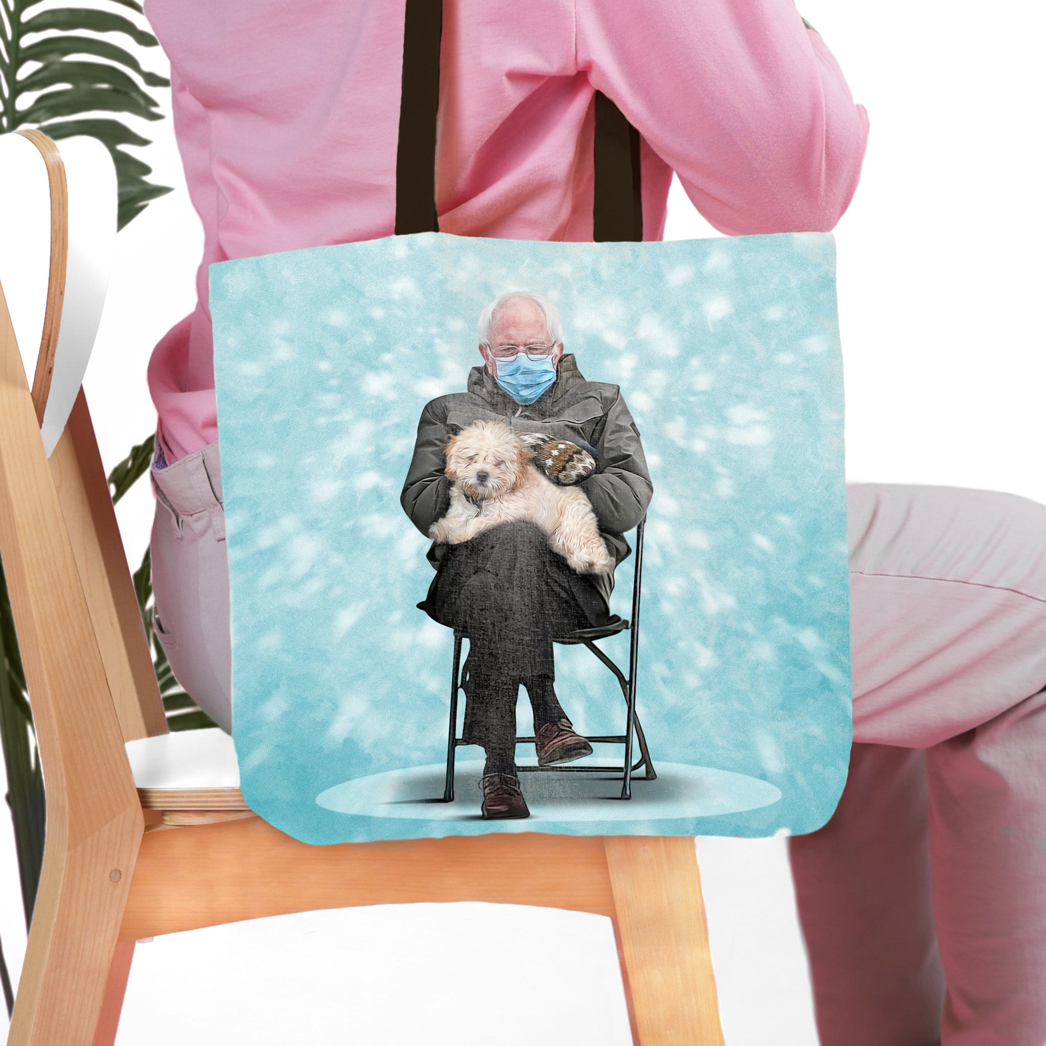 Personalized tote bag with a custom portrait of a man in a mask holding a fluffy dog on a light blue background.