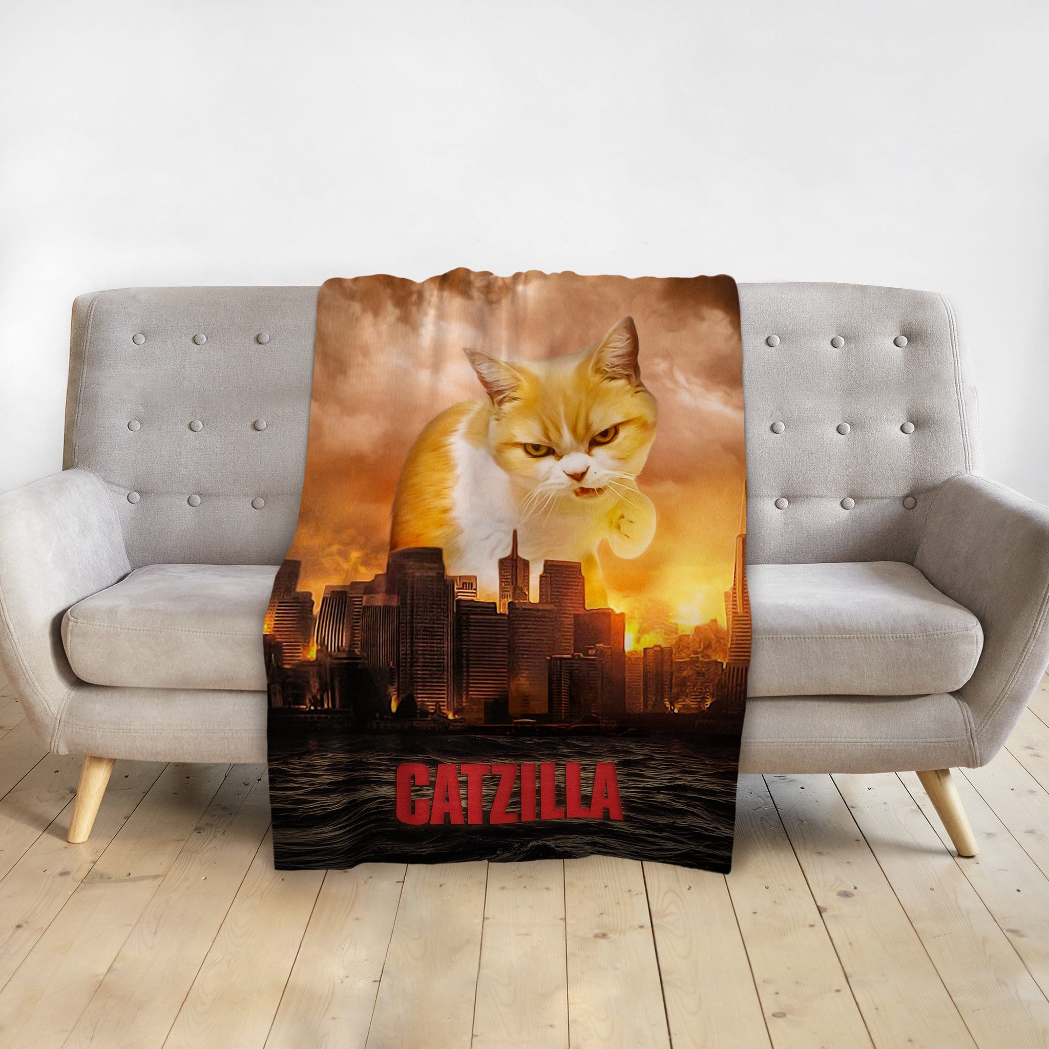 Personalized 'Catzilla' pet blanket with a giant cat portrait over a city skyline at sunset.