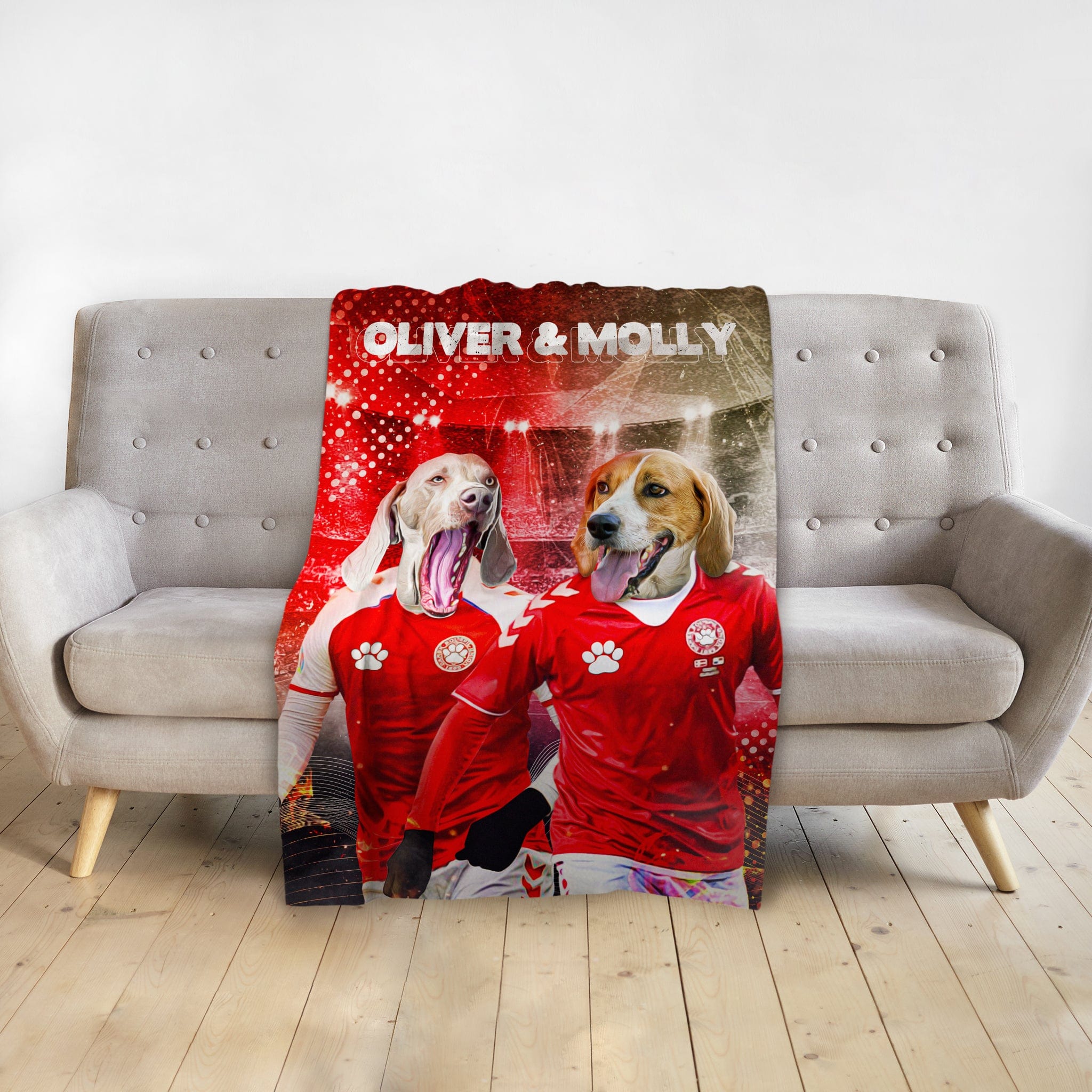Personalized pet blanket with two dogs in red soccer jerseys, named Oliver &amp; Molly, on a gray sofa.