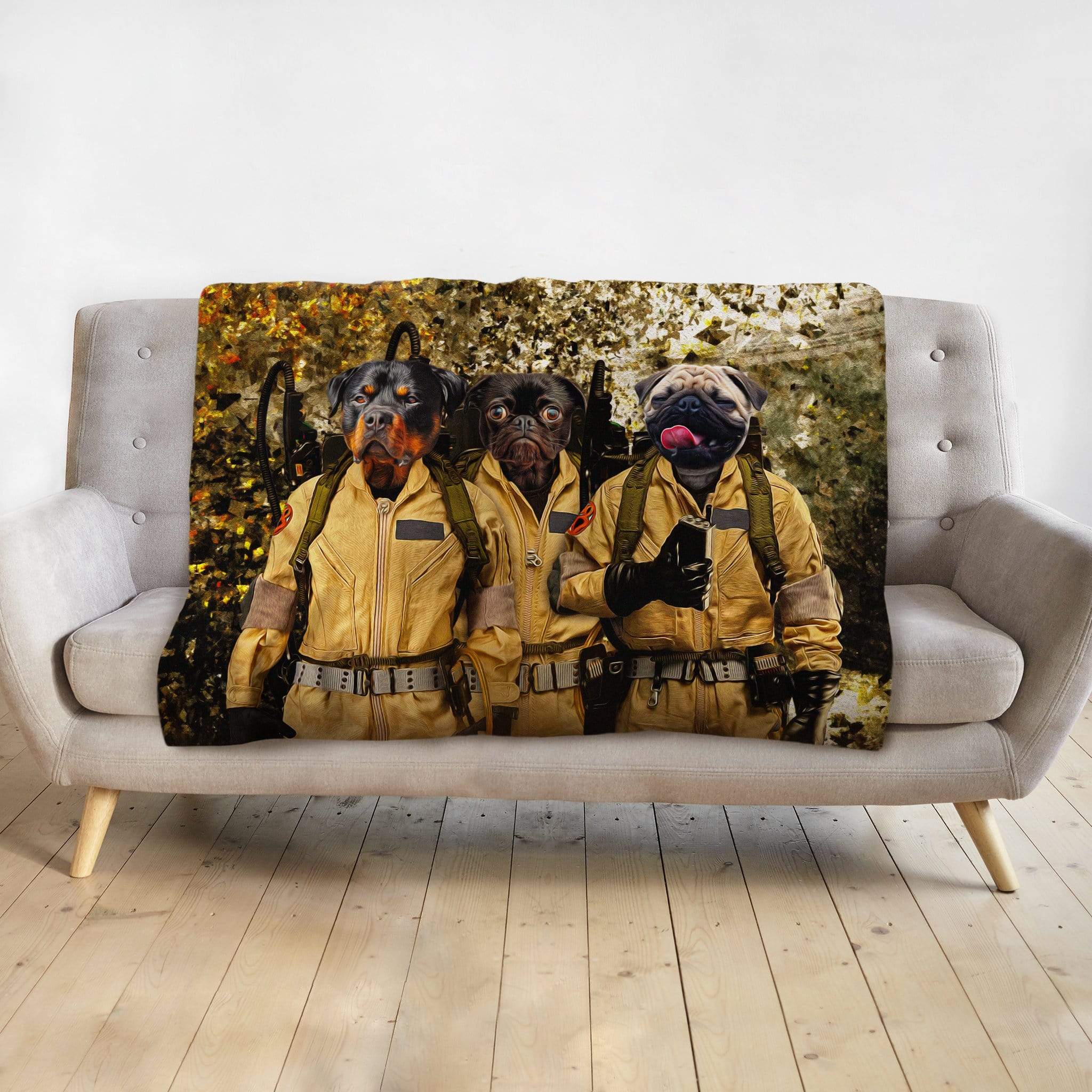 Personalized pet portrait blanket featuring three dogs dressed as Ghostbusters on a gray sofa.