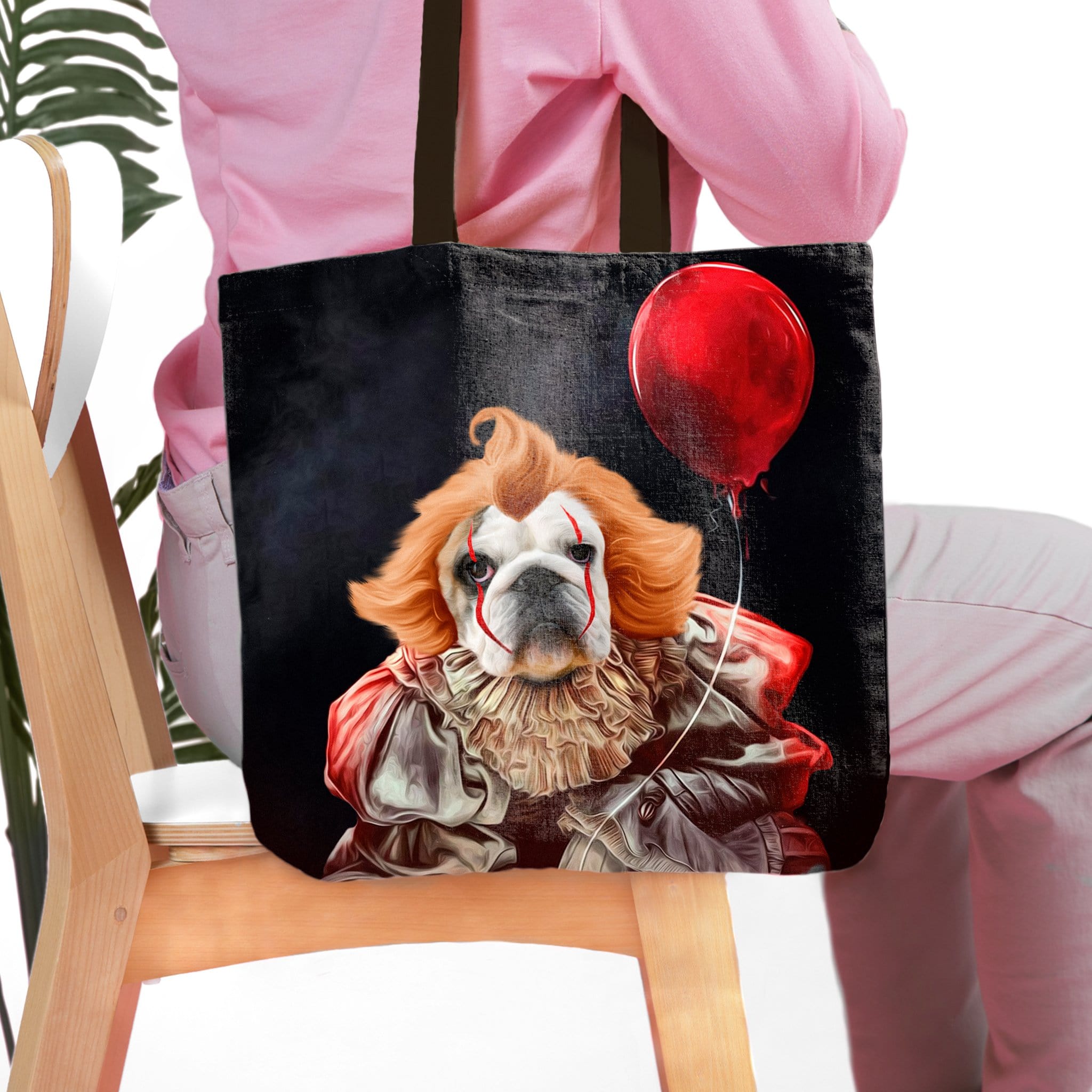 Personalized black tote bag with a custom pet portrait of a bulldog dressed as Pennywise holding a red balloon.