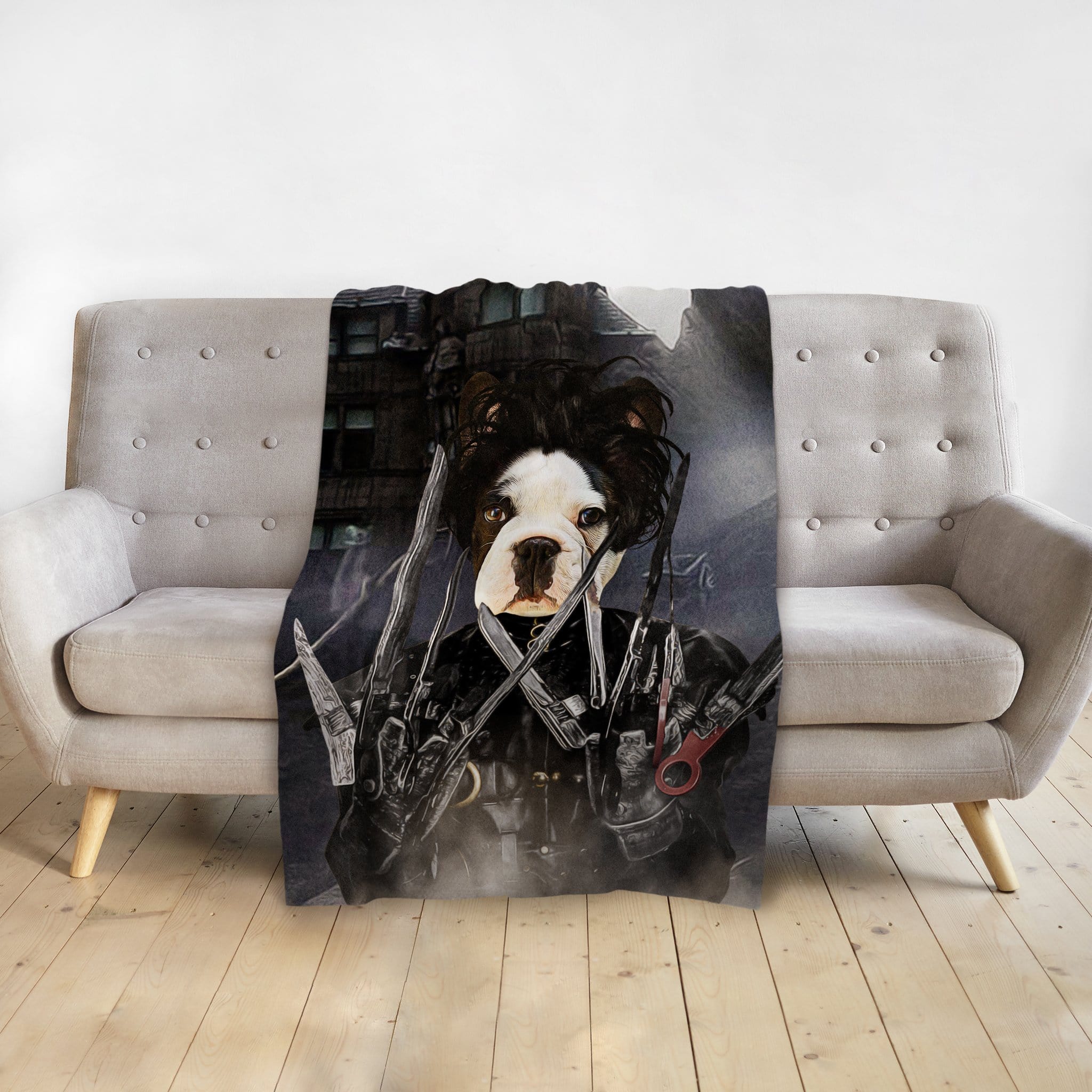 Personalized pet blanket with a dog portrait as Edward Scissorpaws, draped over a gray sofa.
