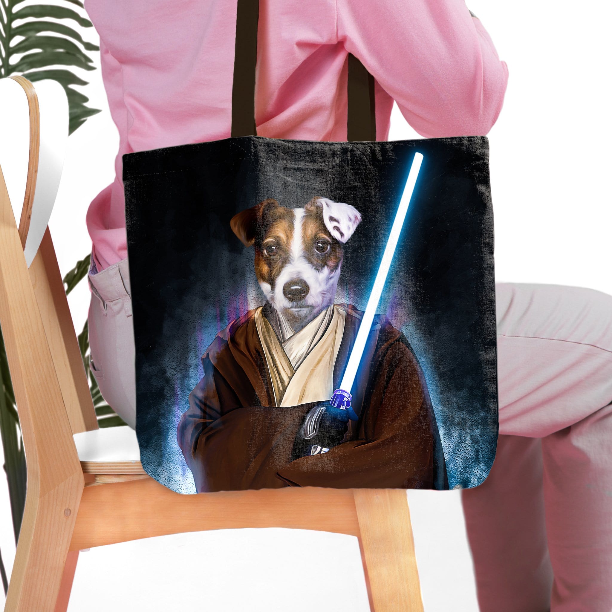 Personalized black tote bag with a custom pet portrait of a Jack Russell dog as a Jedi, holding a blue lightsaber.