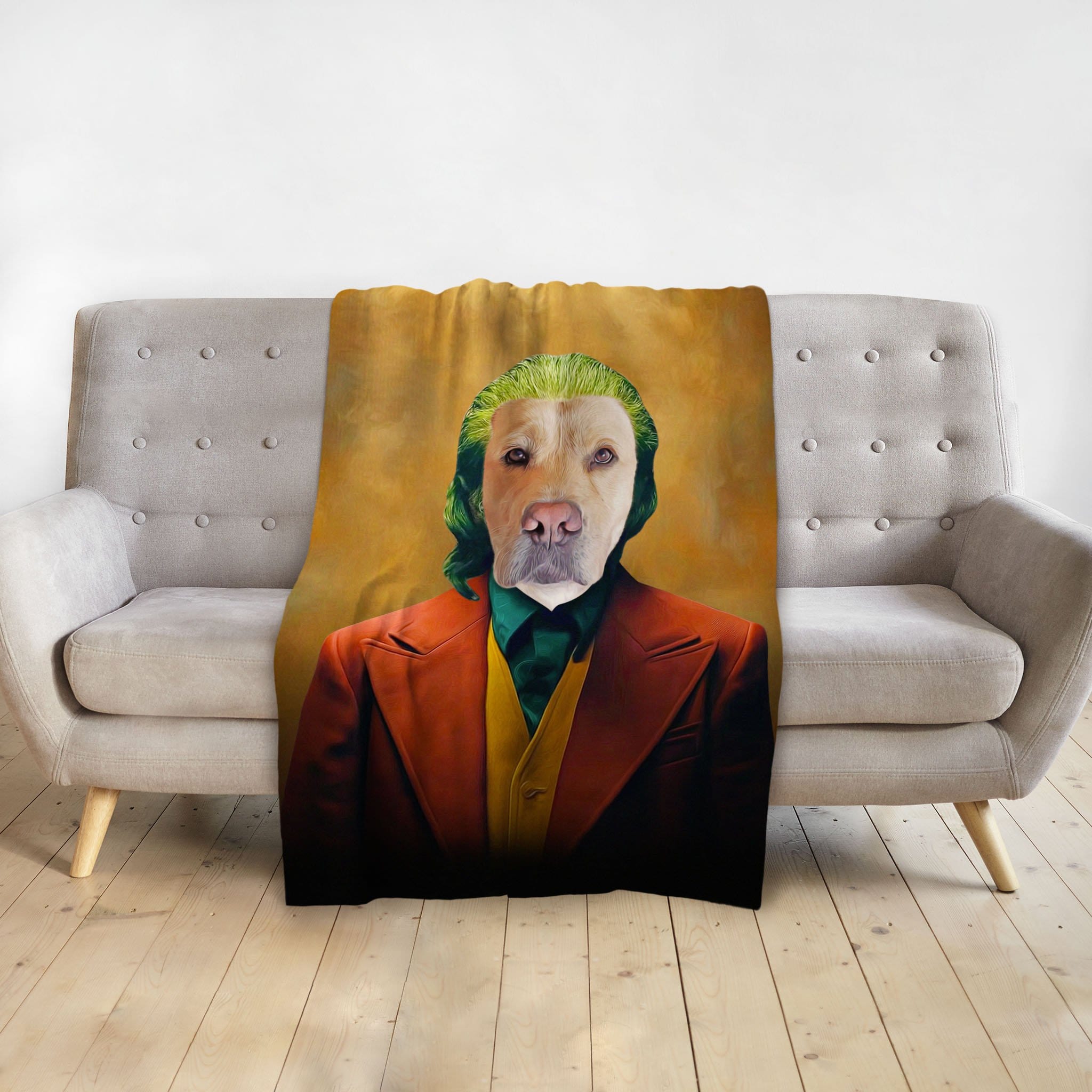 Personalized pet blanket with a dog portrait in a Joker-style costume, draped over a gray sofa.