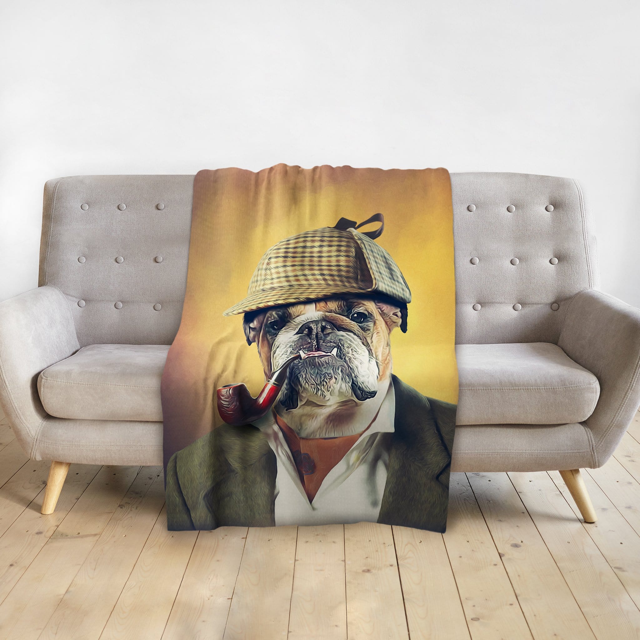Personalized pet blanket with a bulldog in a Sherlock Doggo portrait, draped over a gray sofa.