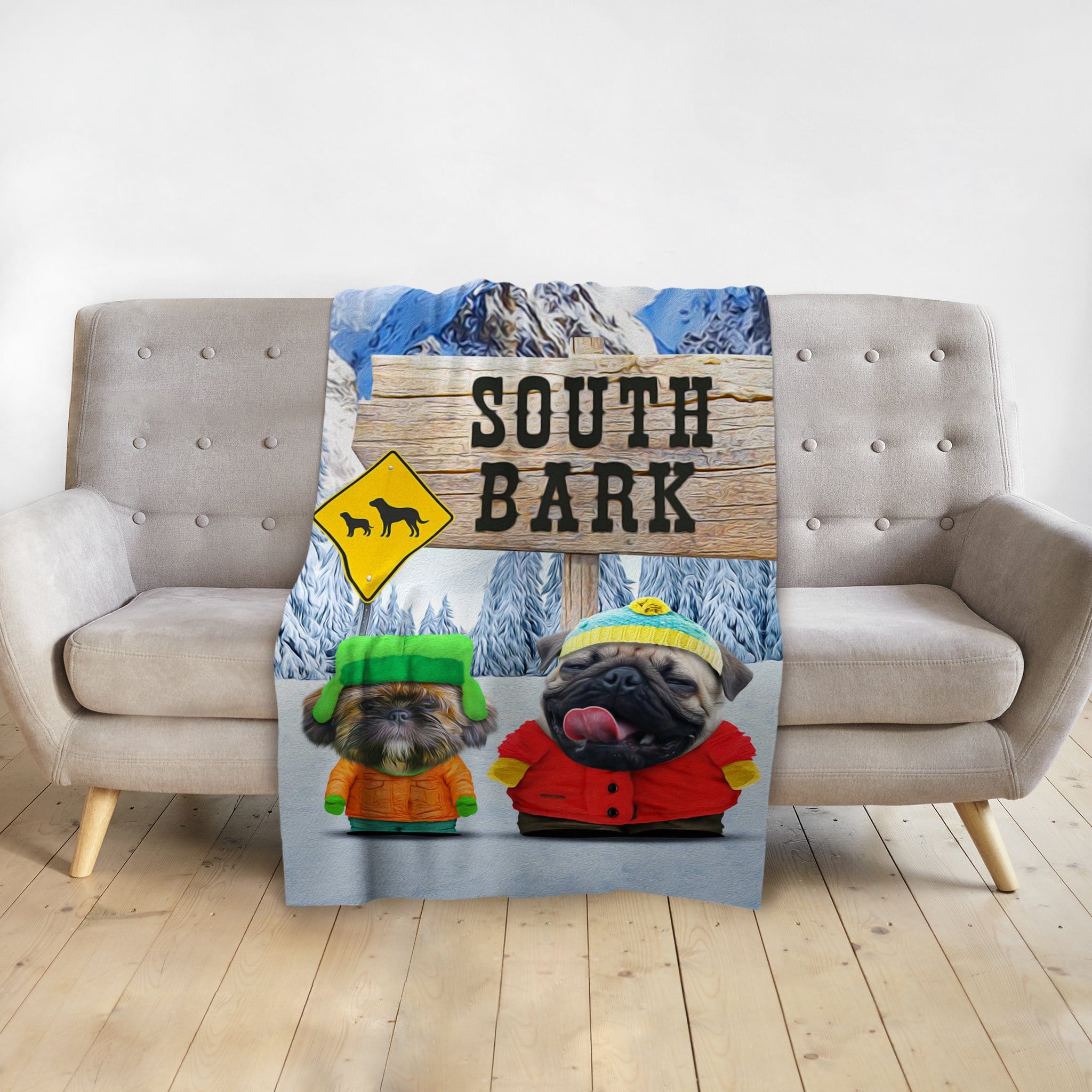 Personalized South Bark blanket featuring two dogs in cartoon style, draped over a gray sofa.