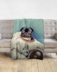 Personalized pet blanket with a black pug in an astronaut portrait design on a gray sofa.