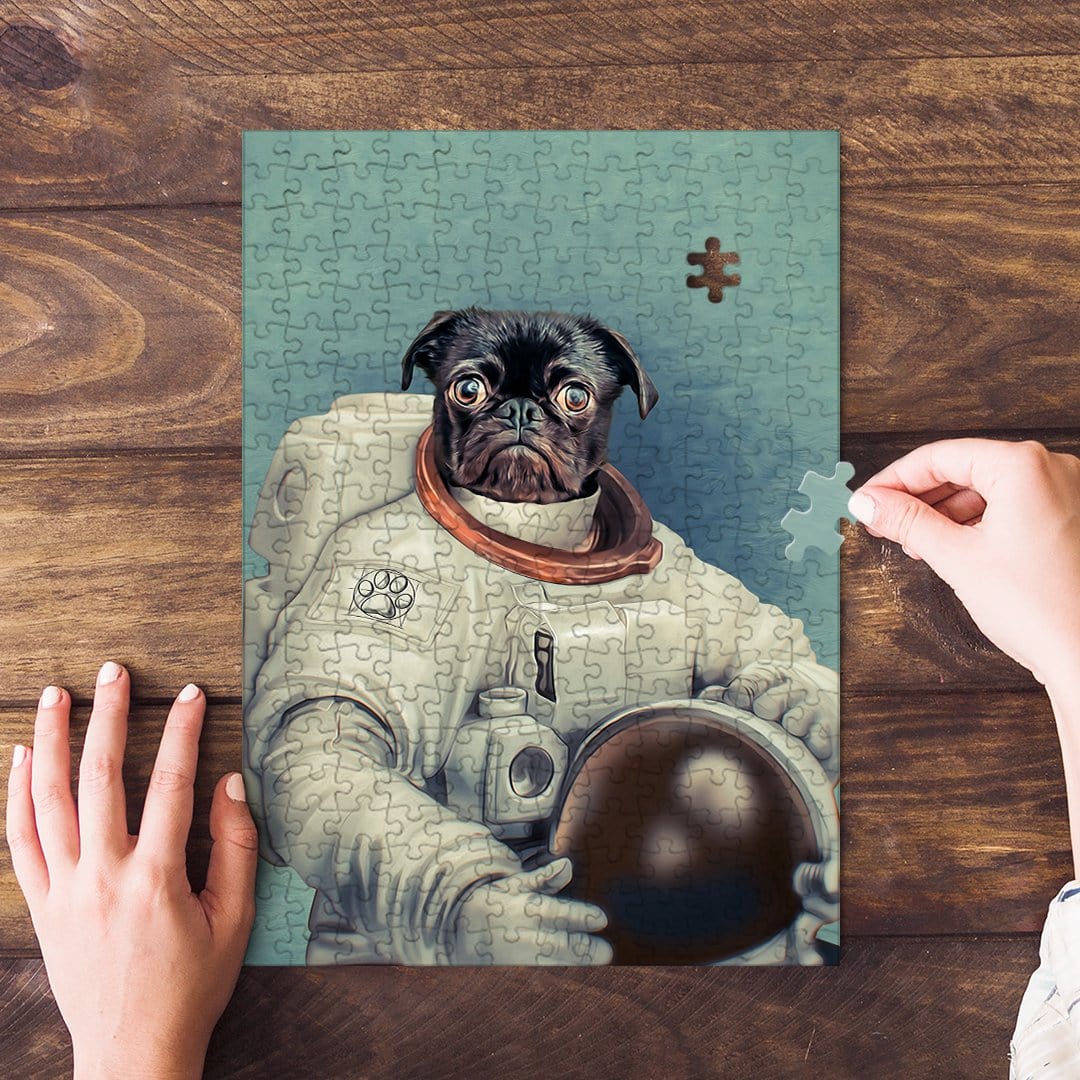 Personalized pet puzzle featuring a black pug in an astronaut suit, with hands assembling pieces.