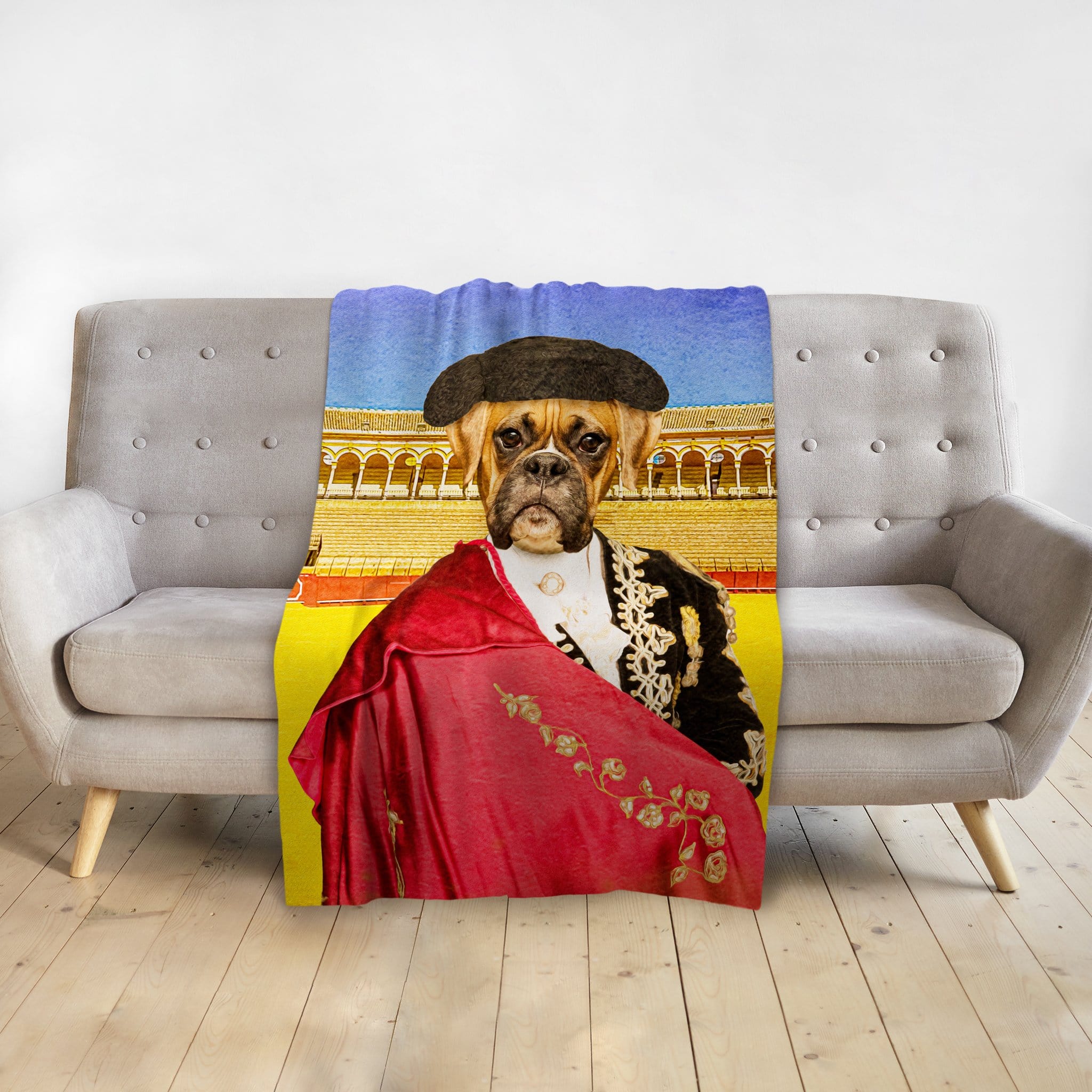 Personalized pet blanket with a boxer dog in a bullfighter portrait, draped over a gray couch.
