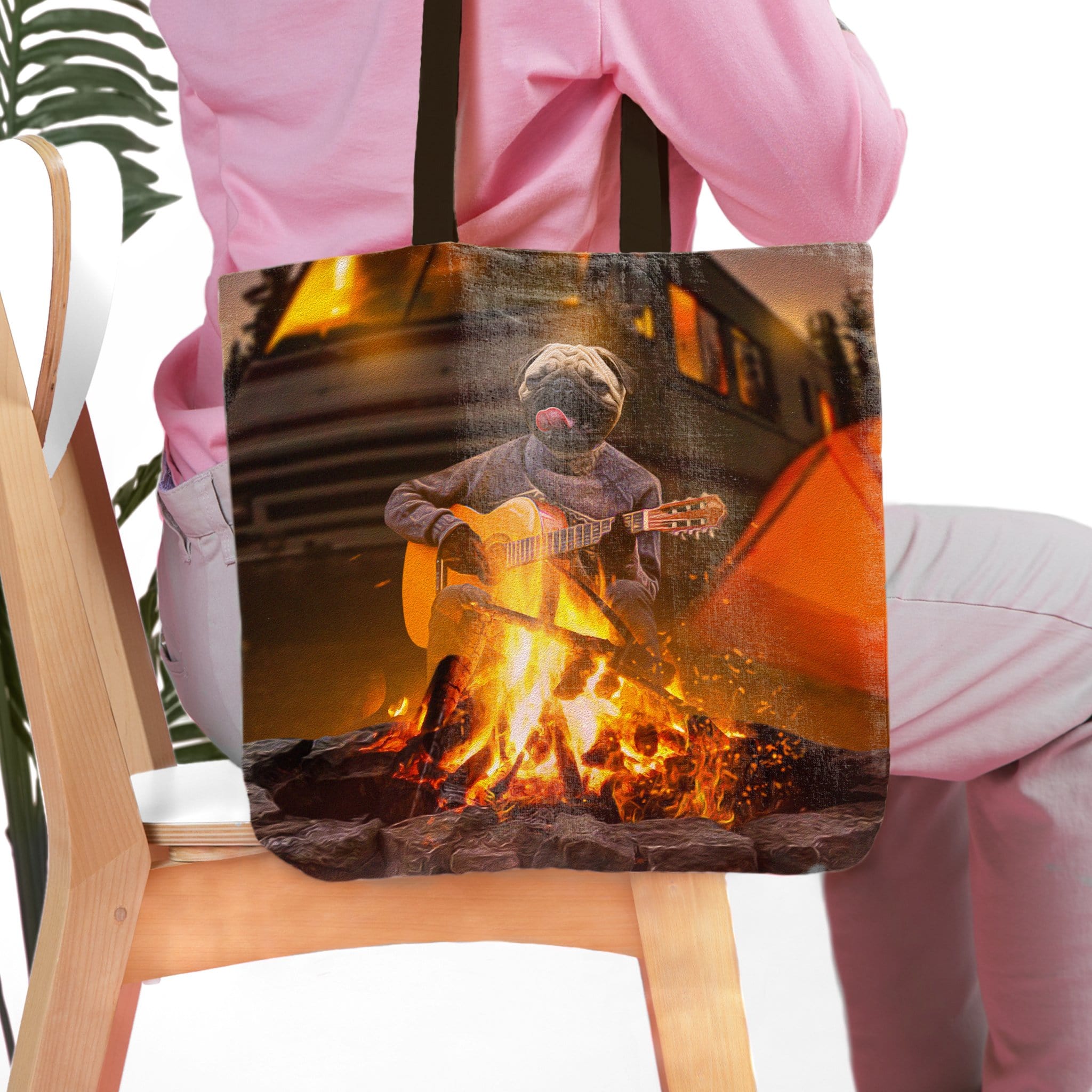 Personalized pet portrait tote bag featuring a pug playing guitar by a campfire.
