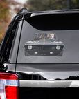 Custom pet decal of a dog driving a black classic car, applied to the rear window of a black SUV.