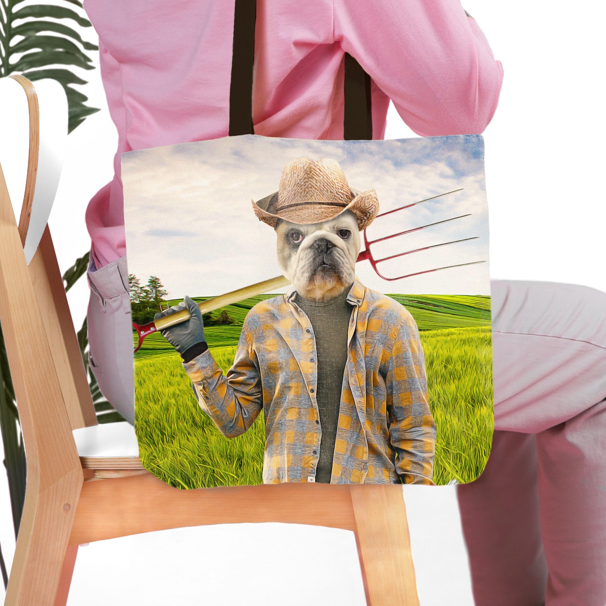 Personalized tote bag with a bulldog pet portrait in a farmer outfit holding a pitchfork in a green field.