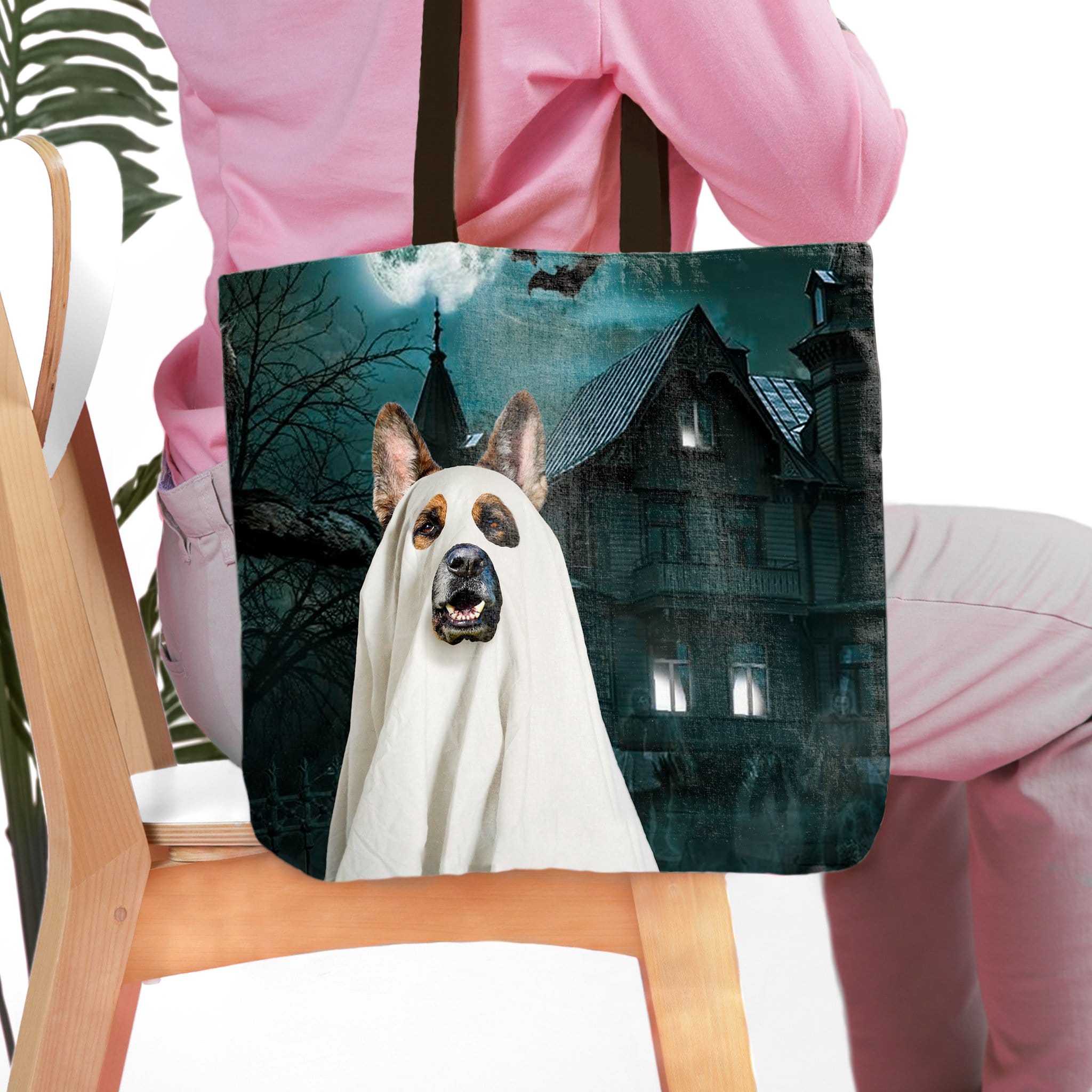 Personalized pet portrait tote bag featuring a dog in a ghost costume before a haunted house.