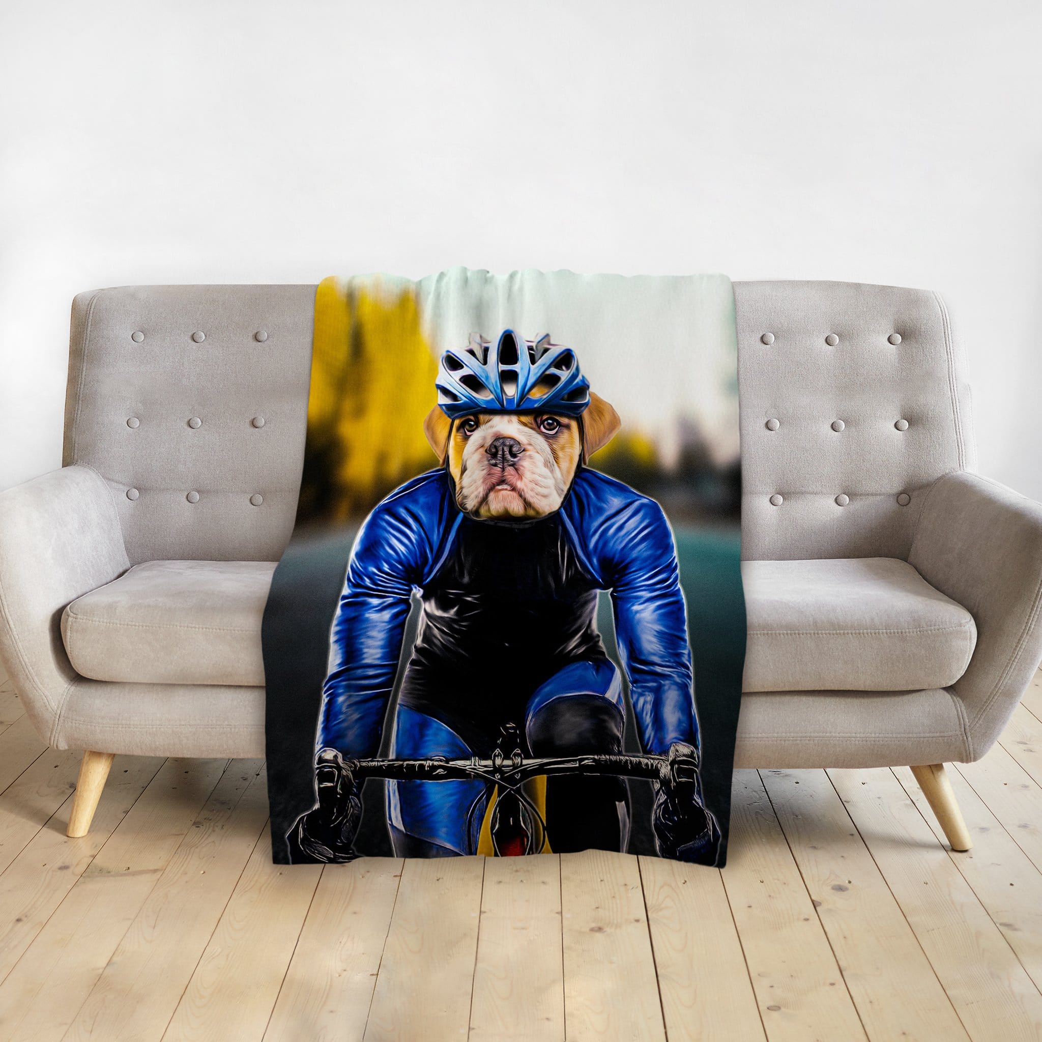 Personalized pet blanket with a bulldog's head on a male cyclist's body, draped over a gray couch.