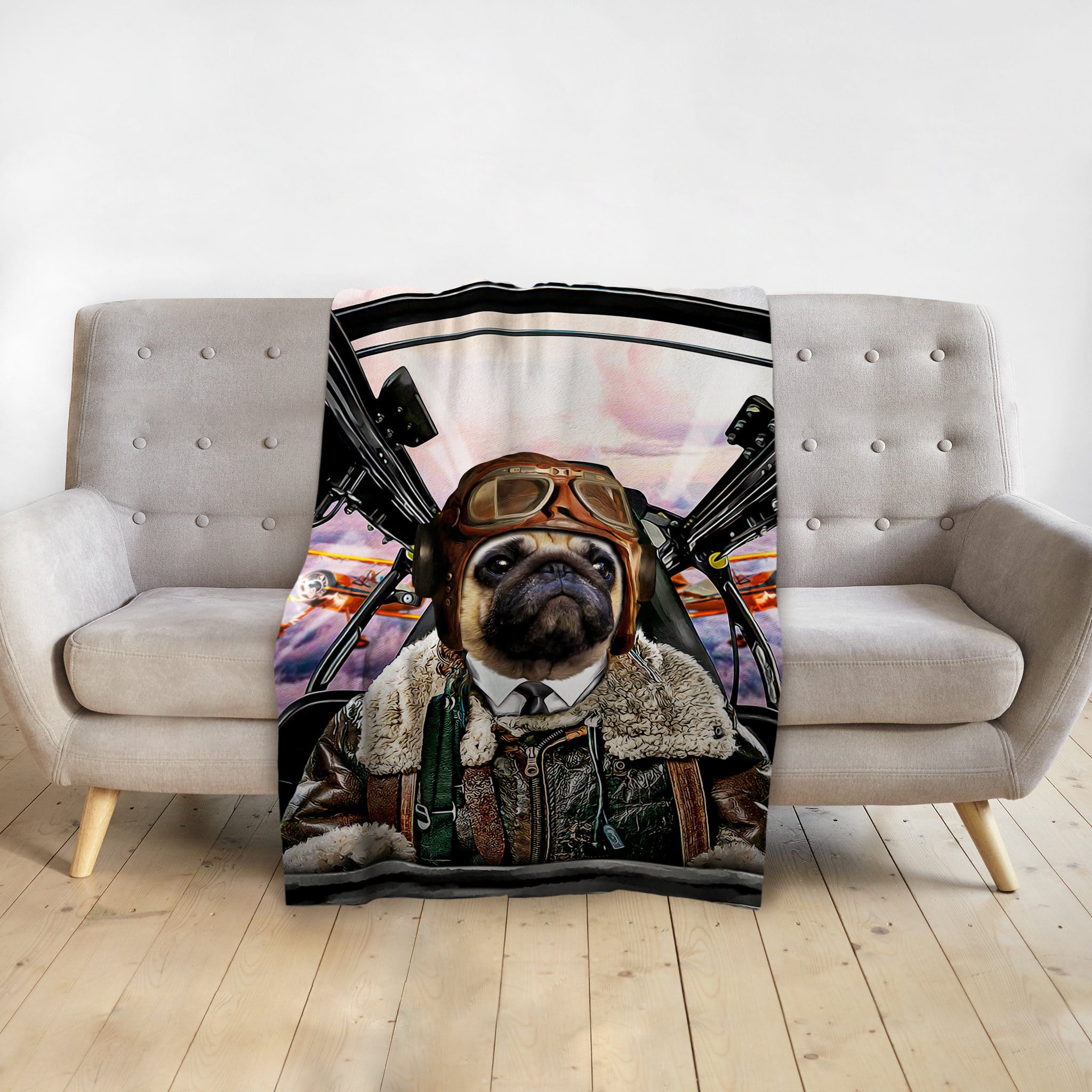 Personalized pet blanket featuring a pug in a pilot's uniform, draped over a gray sofa.