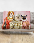 Personalized pink blanket with three dogs in royal renaissance portraits on a gray couch.