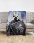 Personalized pet blanket with a bulldog's face on a warrior portrait, draped over a gray couch.