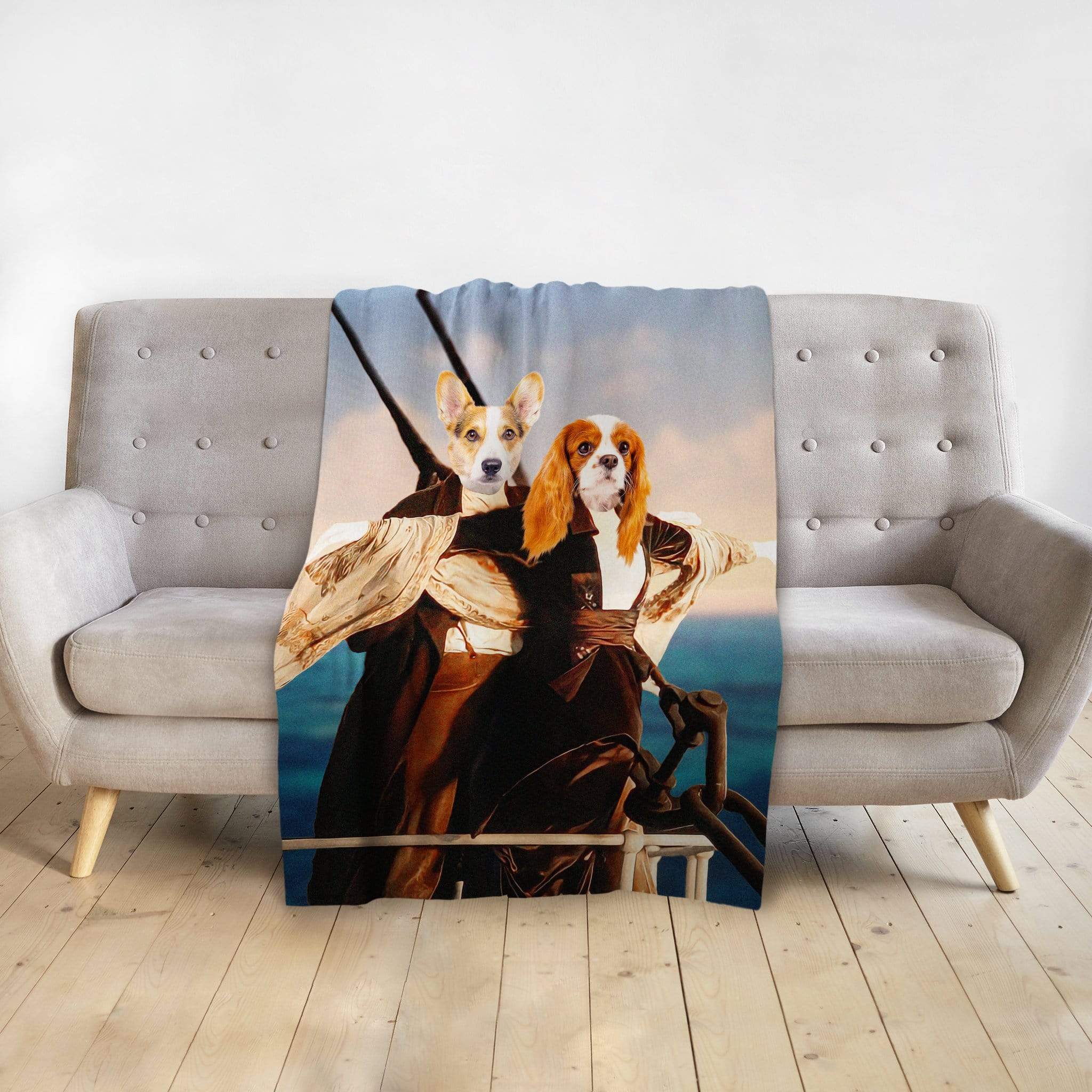 Personalized minky blanket with two dogs in Titanic-style renaissance portraits on a light gray sofa.