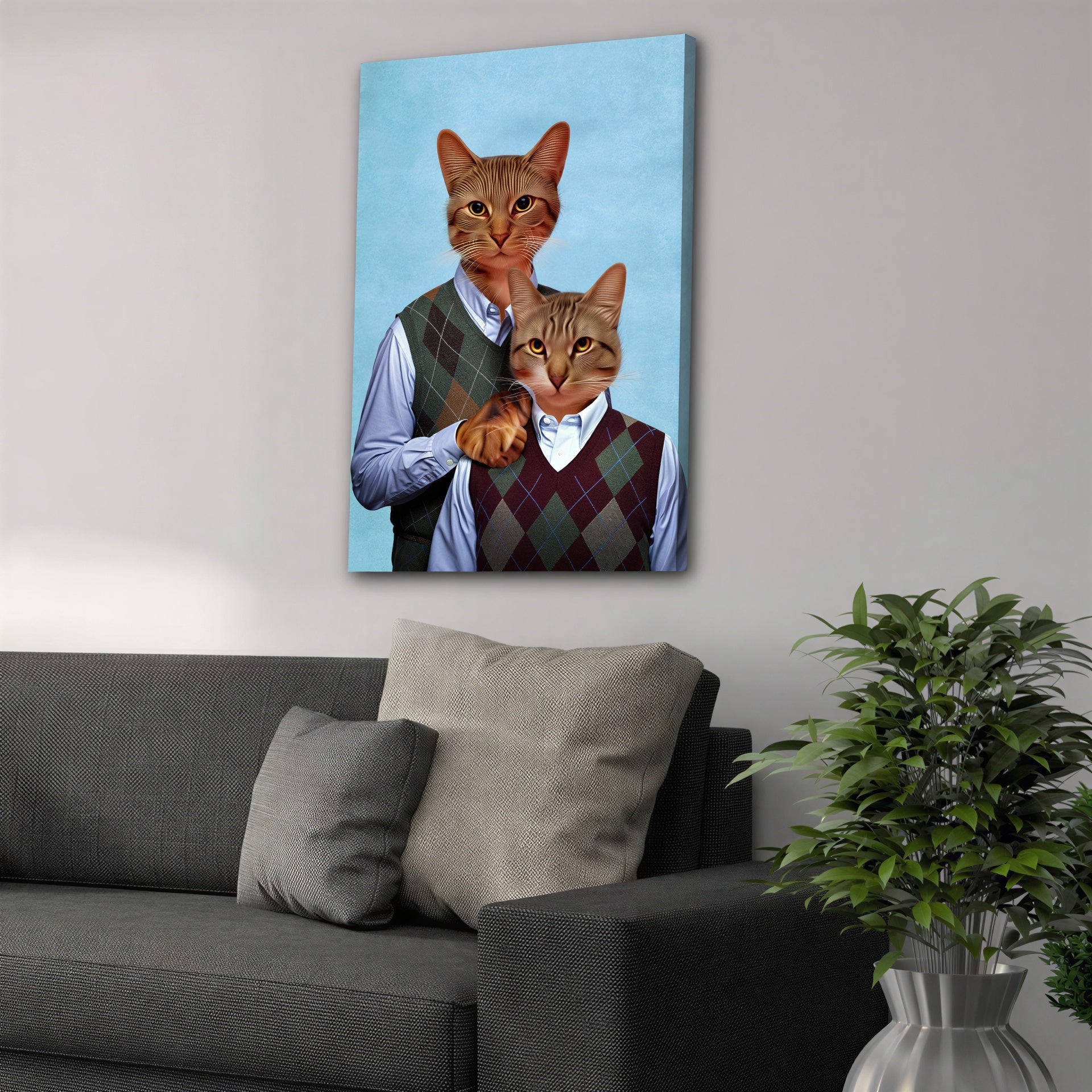 Two personalized cats in argyle sweaters on a blue canvas, hanging above a gray sofa.
